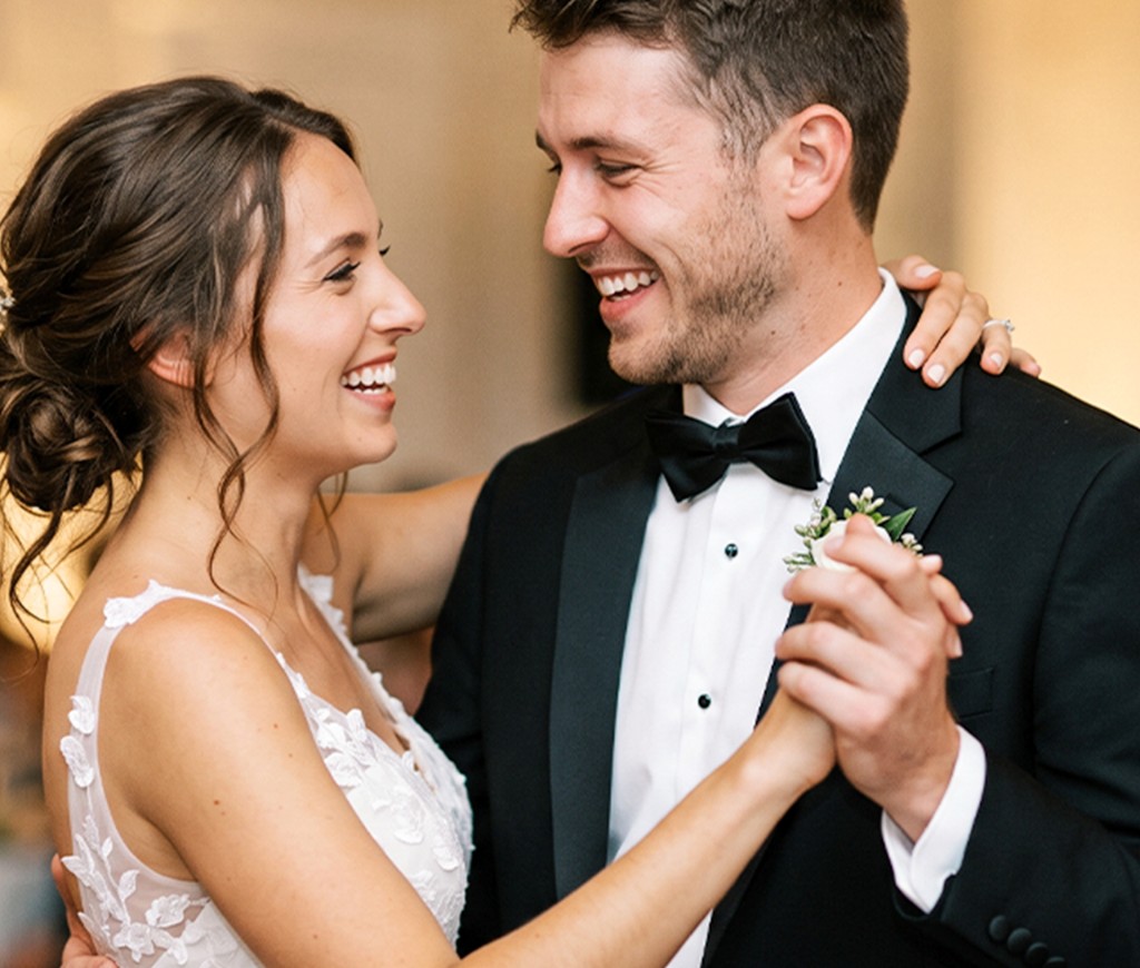 Couple in wedding attire with a floral bouquet